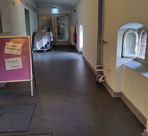 Links ein Aufsteller mit der Aufschrift: Herzlich Willkommen, Arca e.V., Fasiathek